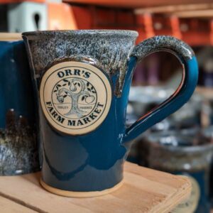 tall, green coffee mug with logo