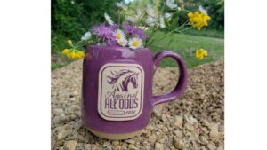 purple coffee mug with a brand logo filled with flowers