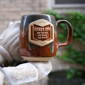 brown and green coffee mug on a concrete platform